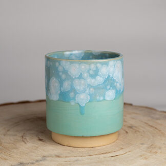 hoge stapelbare mok met effect glazuur aan de bovenste helft en egaal glazuur aan de onderste helft in kleur lichtblauw gemaakt van keramiek